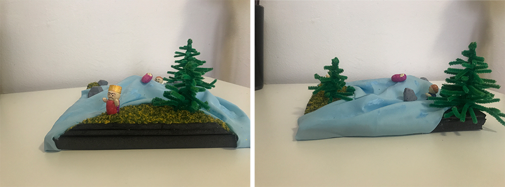 A miniature model of a river running through trees with a person standing next to the river.