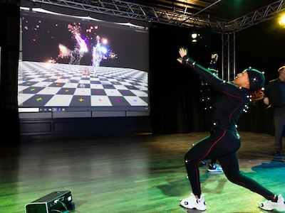 A student tests out motion-capture technology with projections.