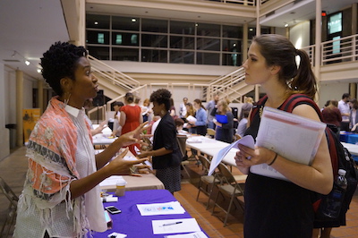 A student talks to a museum working professional during an information fair.