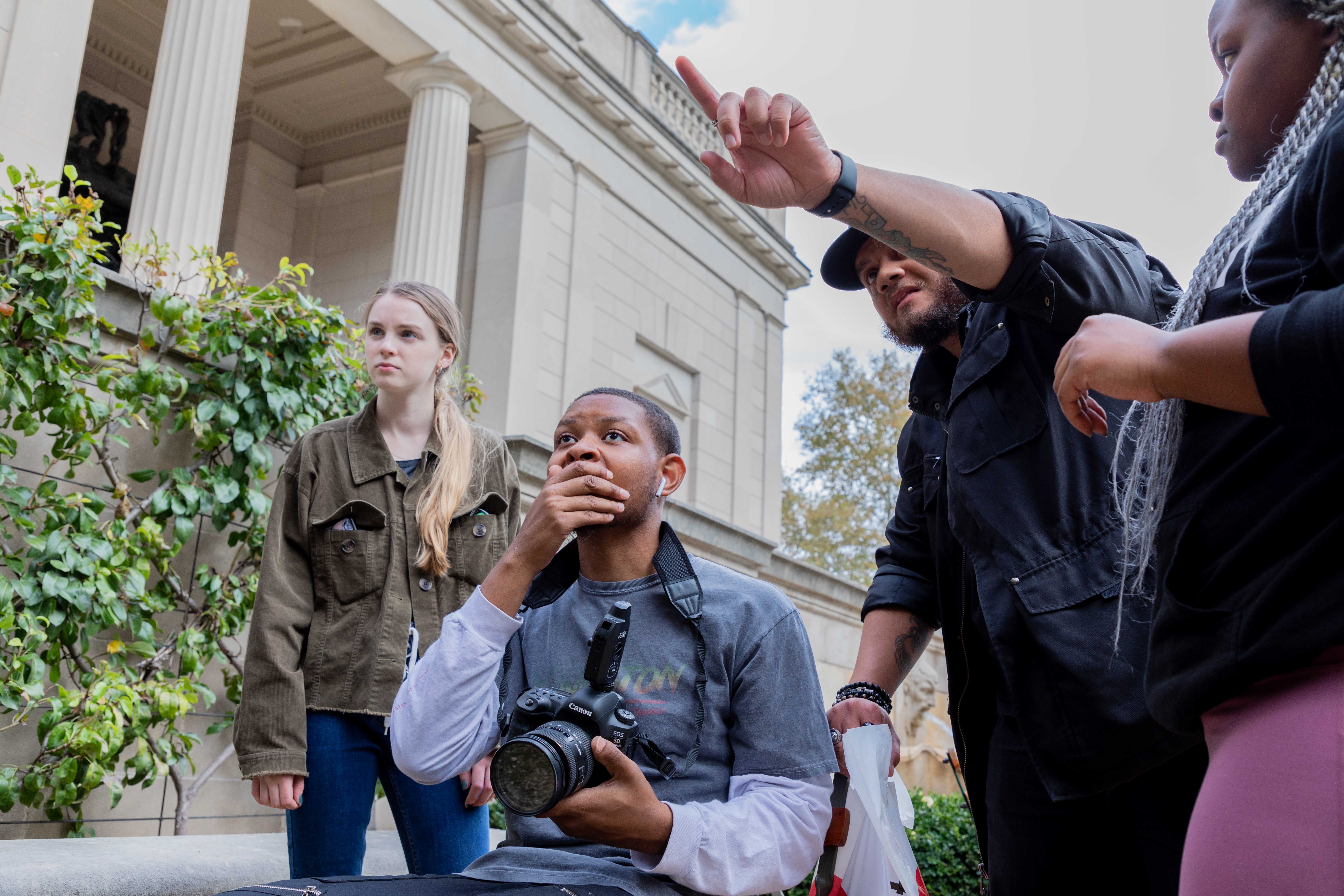 Students pointing to a looking at a photography subject they are about to capture