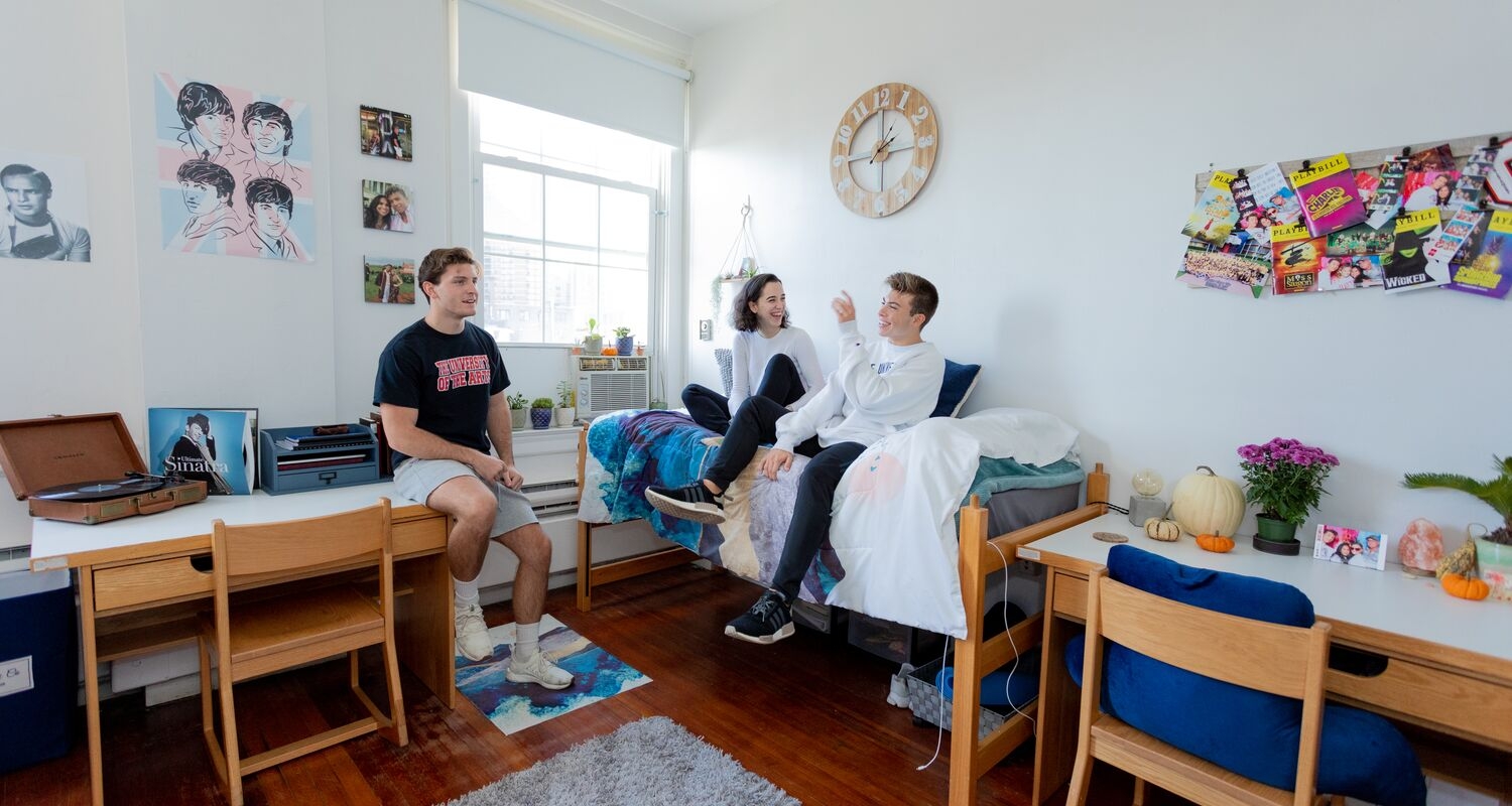 Three students hang out in Spruce residence hall.