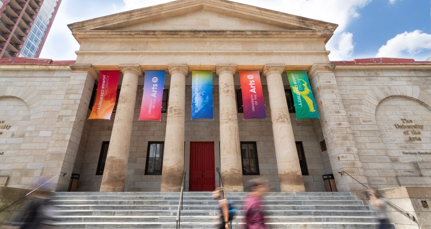 Hamilton Hall decorated with multicolored banners that include a white UArts logo and advancing human creativity in white type