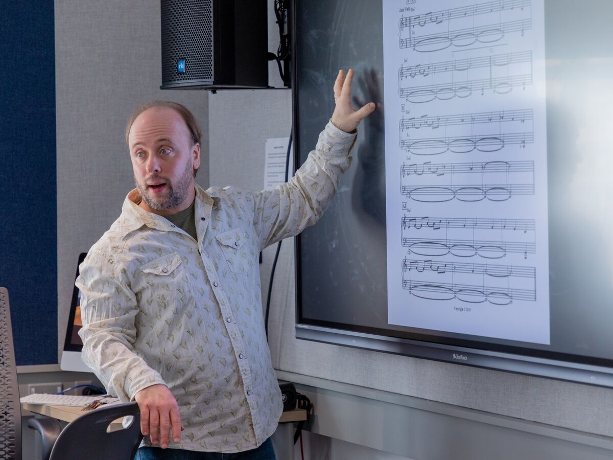 Faculty member Randy Kapralick shows an excerpt to students during class.