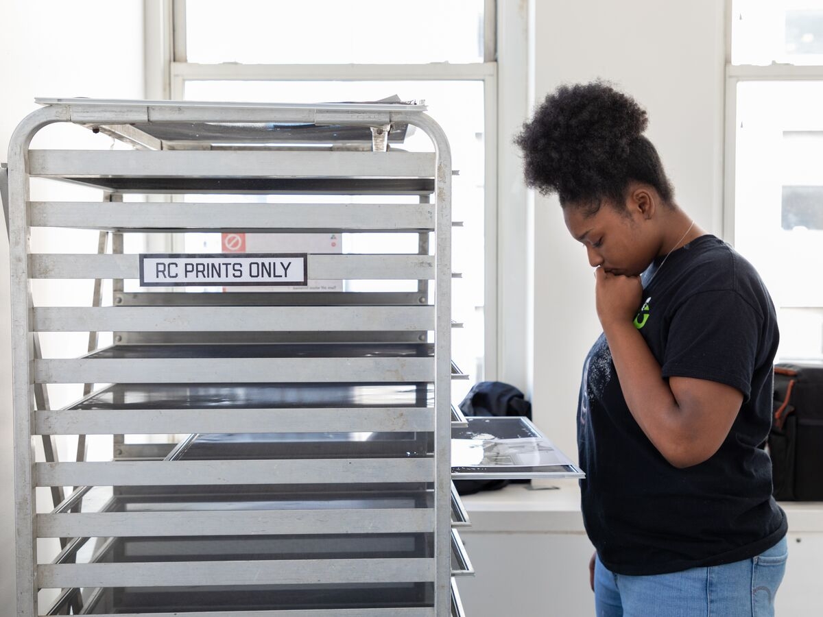 A student inspects their work before drying it on the RC Print rack