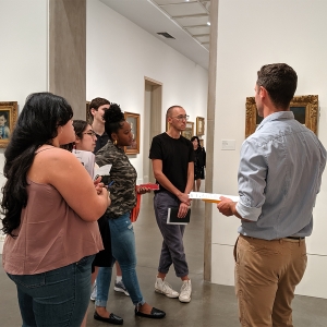 Faculty member Mickey Maley talks to students in front of a piece of art in the Philadelphia Museum of Art.