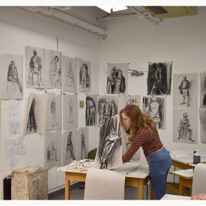 A student works with charcoal in the drawing classroom
