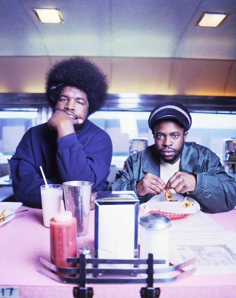 The Roots sit at Silk City diner in Philadelphia with their food and a milkshake.