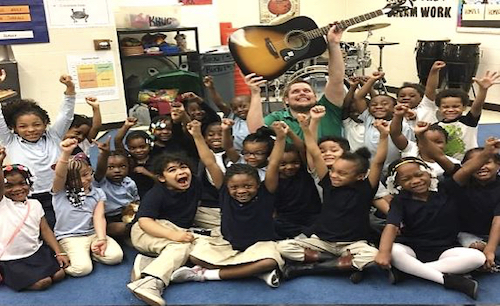 Alum Andrew Kruc (MAT '12) poses with his music class.