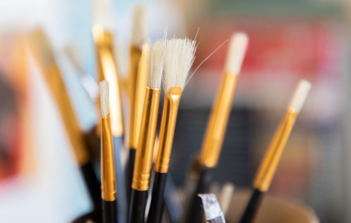 A set of paint brushes in a cup