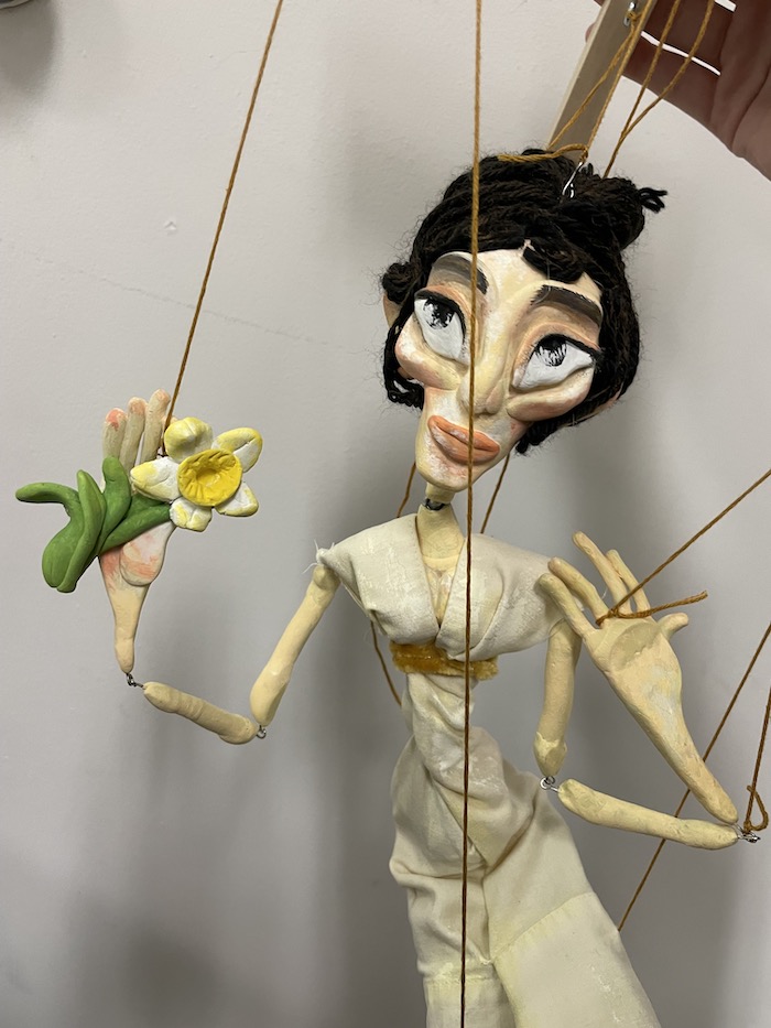 A puppet of a woman from the 1800s made from found and recycled materials.