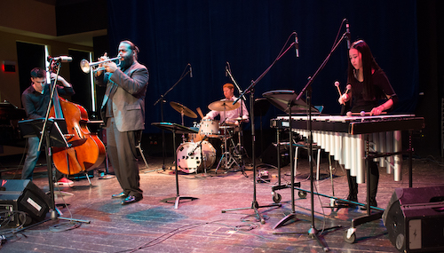 The graduate jazz ensemble performs on stage. Musicians include a vibraphone player, trumpeter, drummer and bassist.