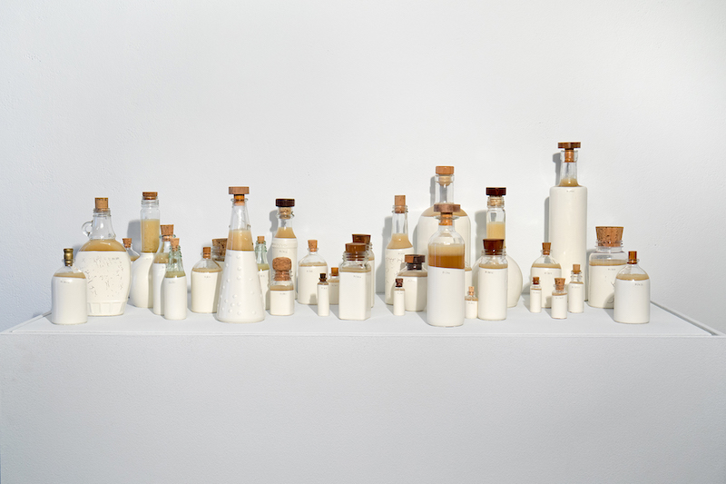 Reclaimed glass bottles filled with white soap created by Shelley Spector