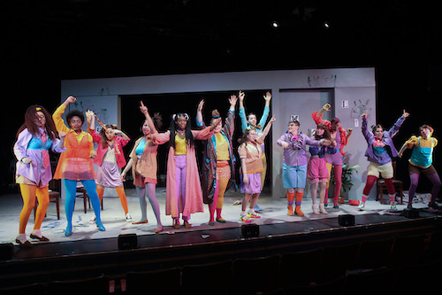 theater students on stage wearing neon colored costumes and make-up