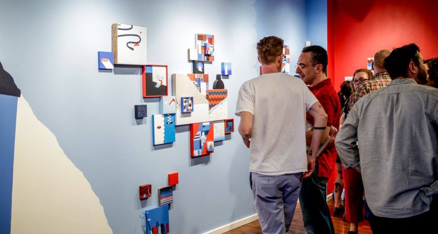 Two men looking at an installation of brightly painted squares on Paradigm Gallery wall