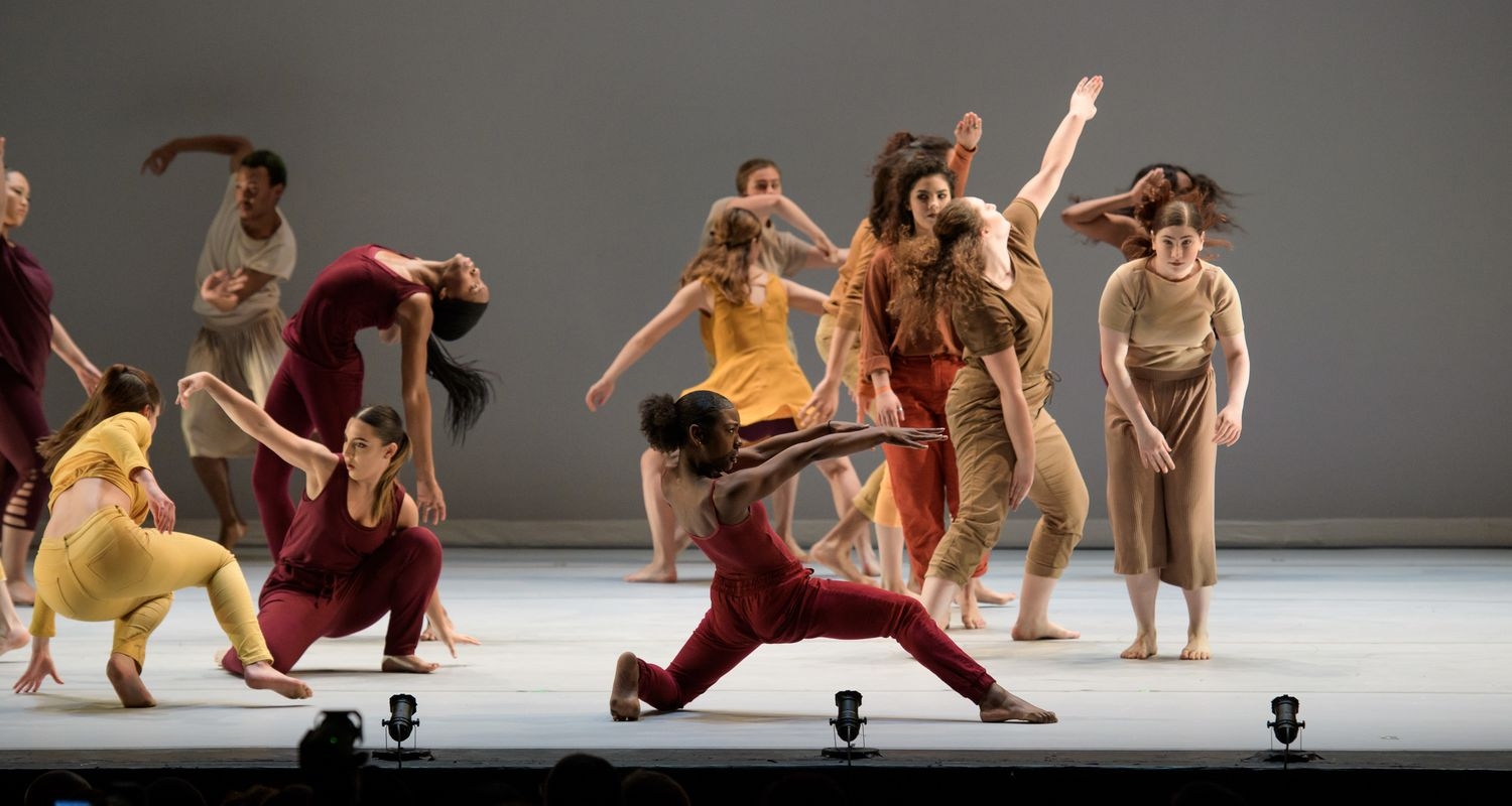 UArts dance students perform in multi-colored outfits on a white stage