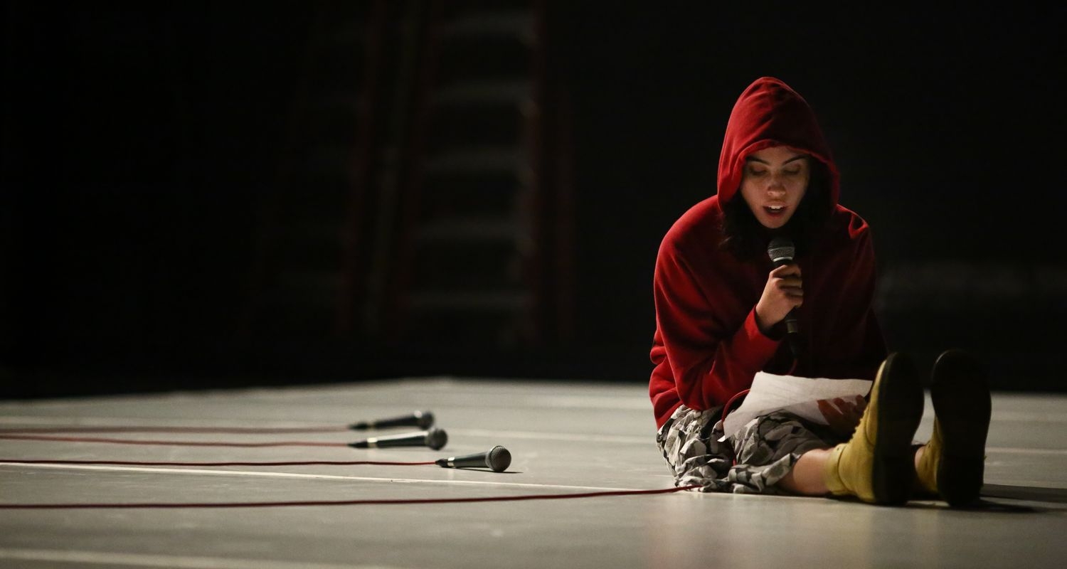 UArts student rehearses on a dark lit stage