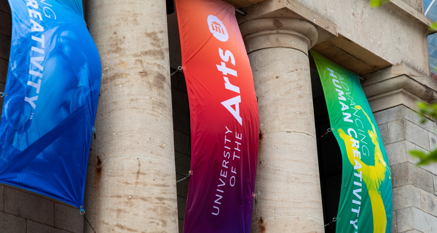 Colorful banners hang between the columns of UArts' Hamilton Hall
