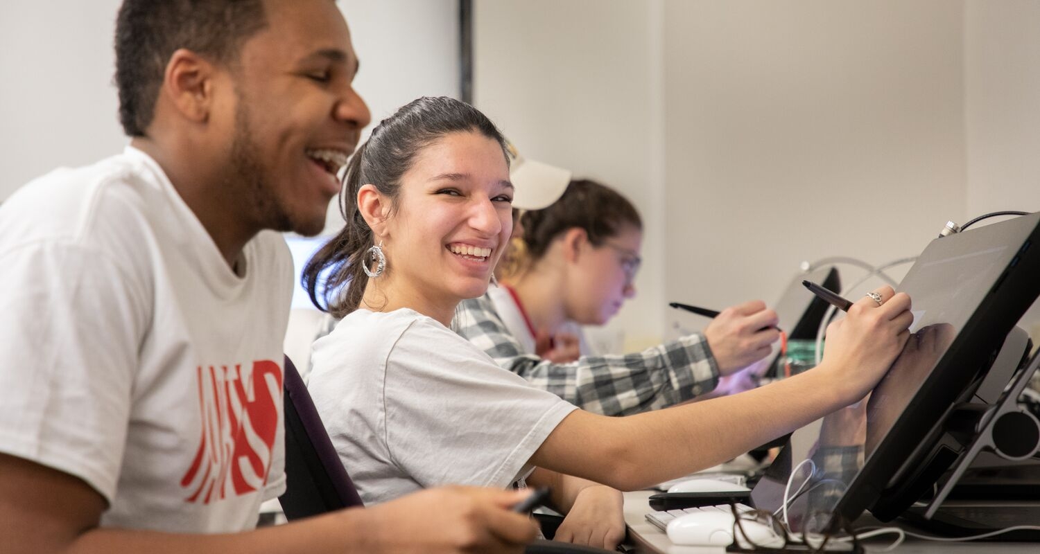 UArts students smile working in an illustration classroom