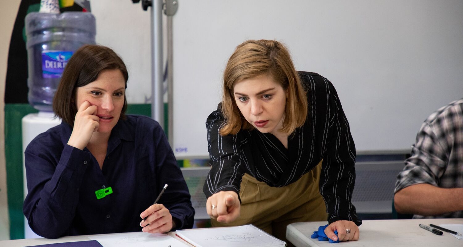 A teacher guides a student through a drawing exercise.