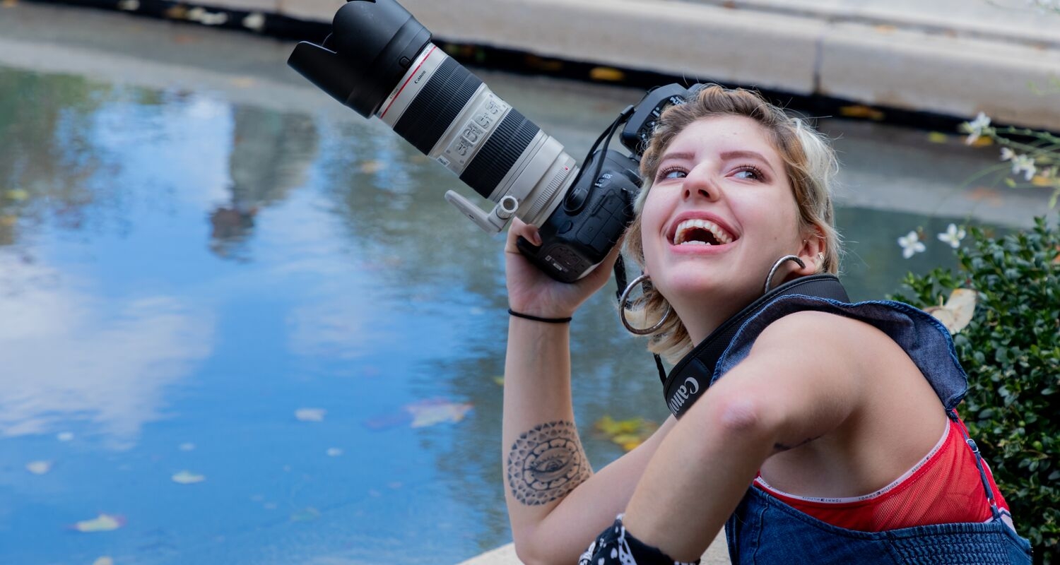 UArts Photography student smiles with a camera
