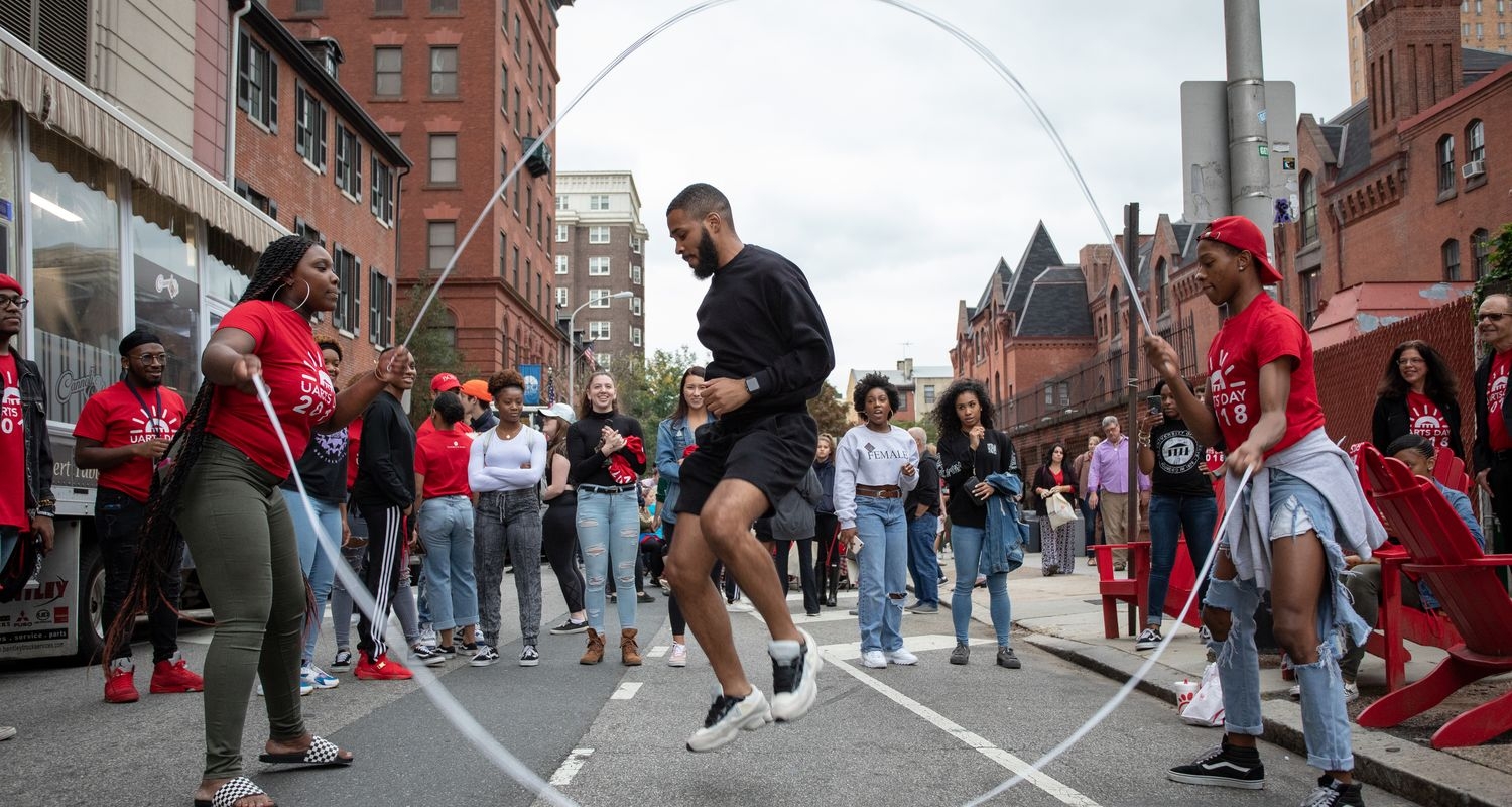 A student does double dutch on Pine St.