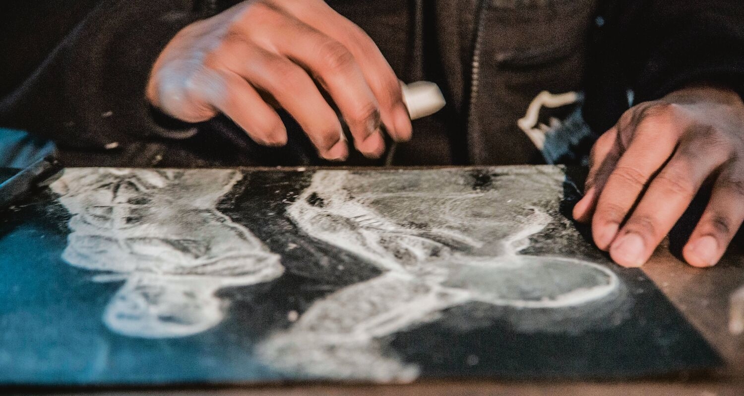 A detail image of a student's hands, using a printmaking technique.