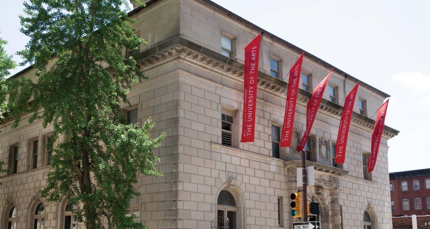 exterior of the Art Alliance building with red banners across the front of the building that read Philadephia Art Alliance at the University of the Arts in white font.