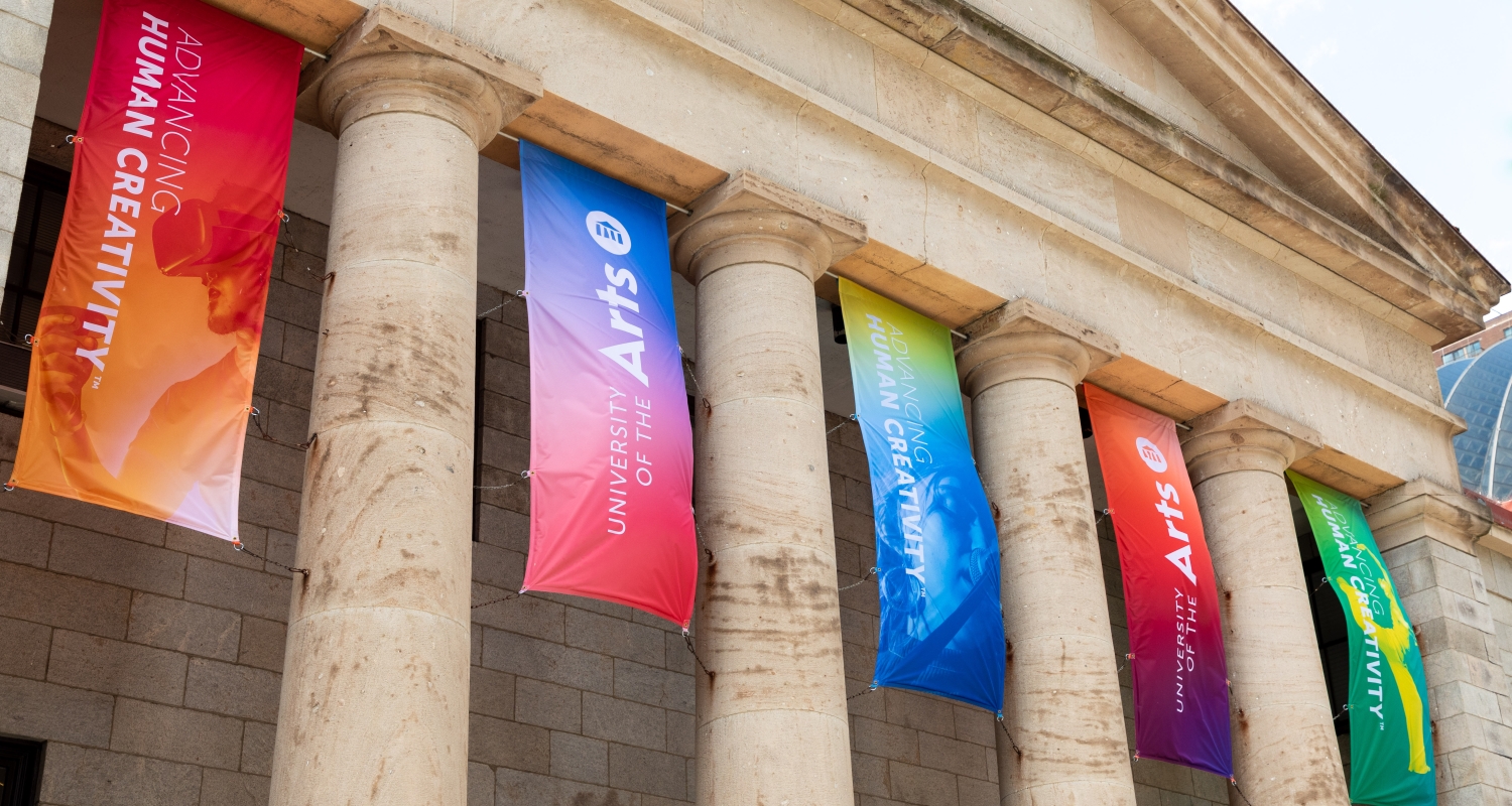 Colorful banners hang between the columns of Hamilton Hall 