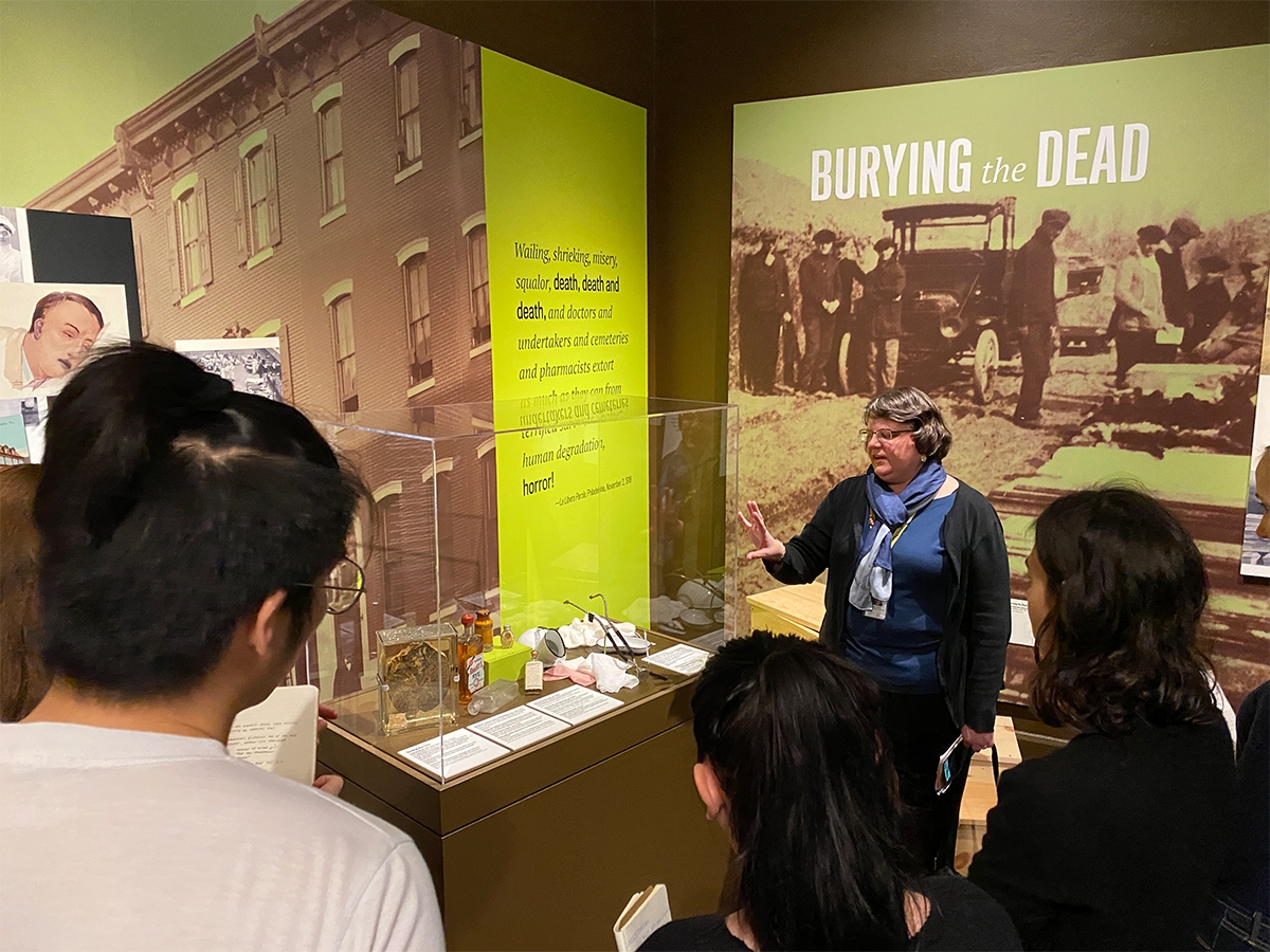 Students look at the exhibit "Burying the Dead" with a tour guide at the Mutter Museum.