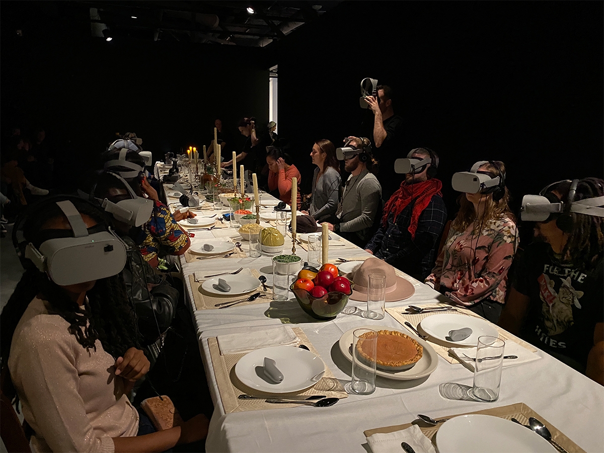 Students sit around a dinner table with virtual reality headgear at Wonderspaces Philadelphia.