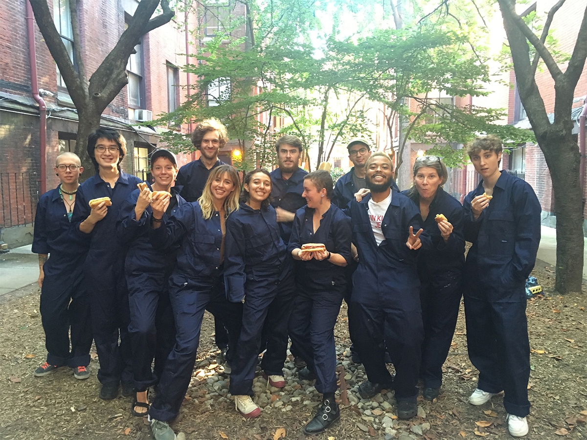 Sculpture students pose together in their coveralls