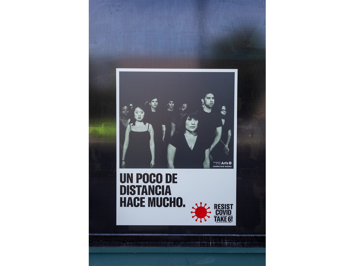 A photograph of a group of people standing six feet apart with the words "un poco de distance hace mucho"