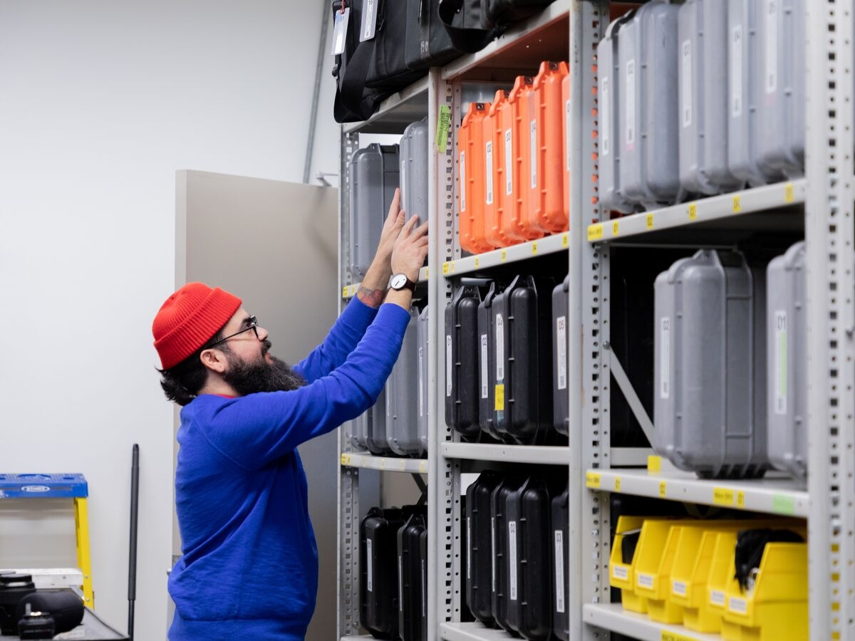 A student worker stacks equipment on a shelf in Media Resources