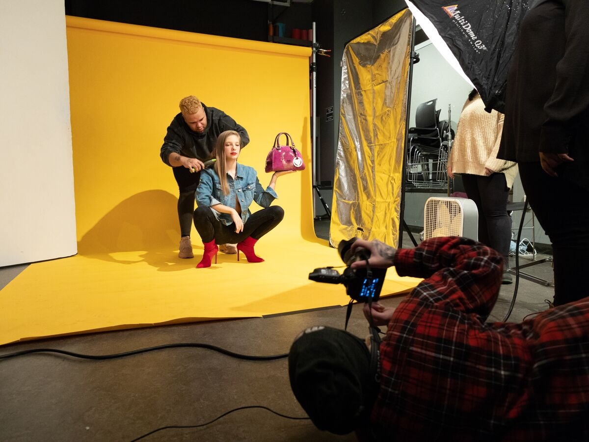 Students work with a model for a photo shoot in the Photography studio