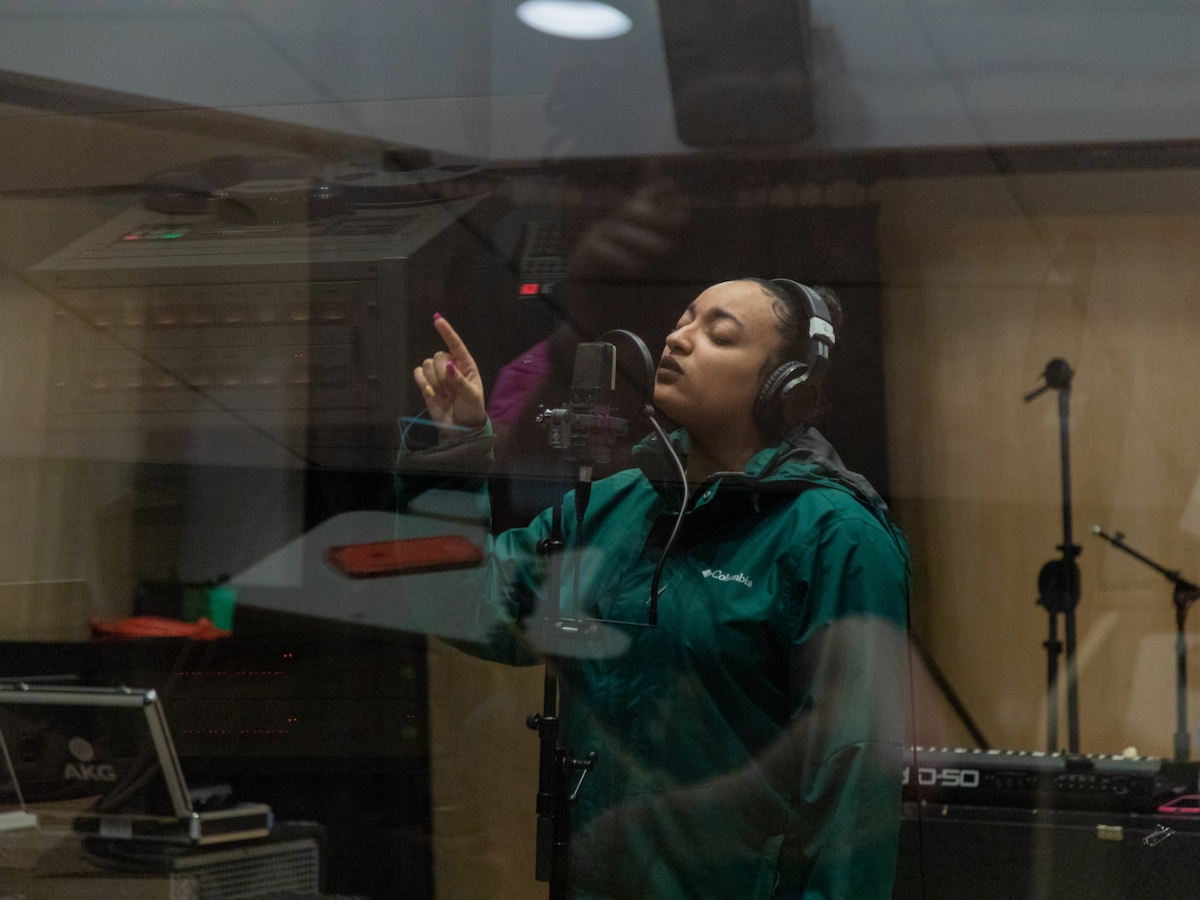A student sings into a microphone in the Laurie Wagman Recording Studios