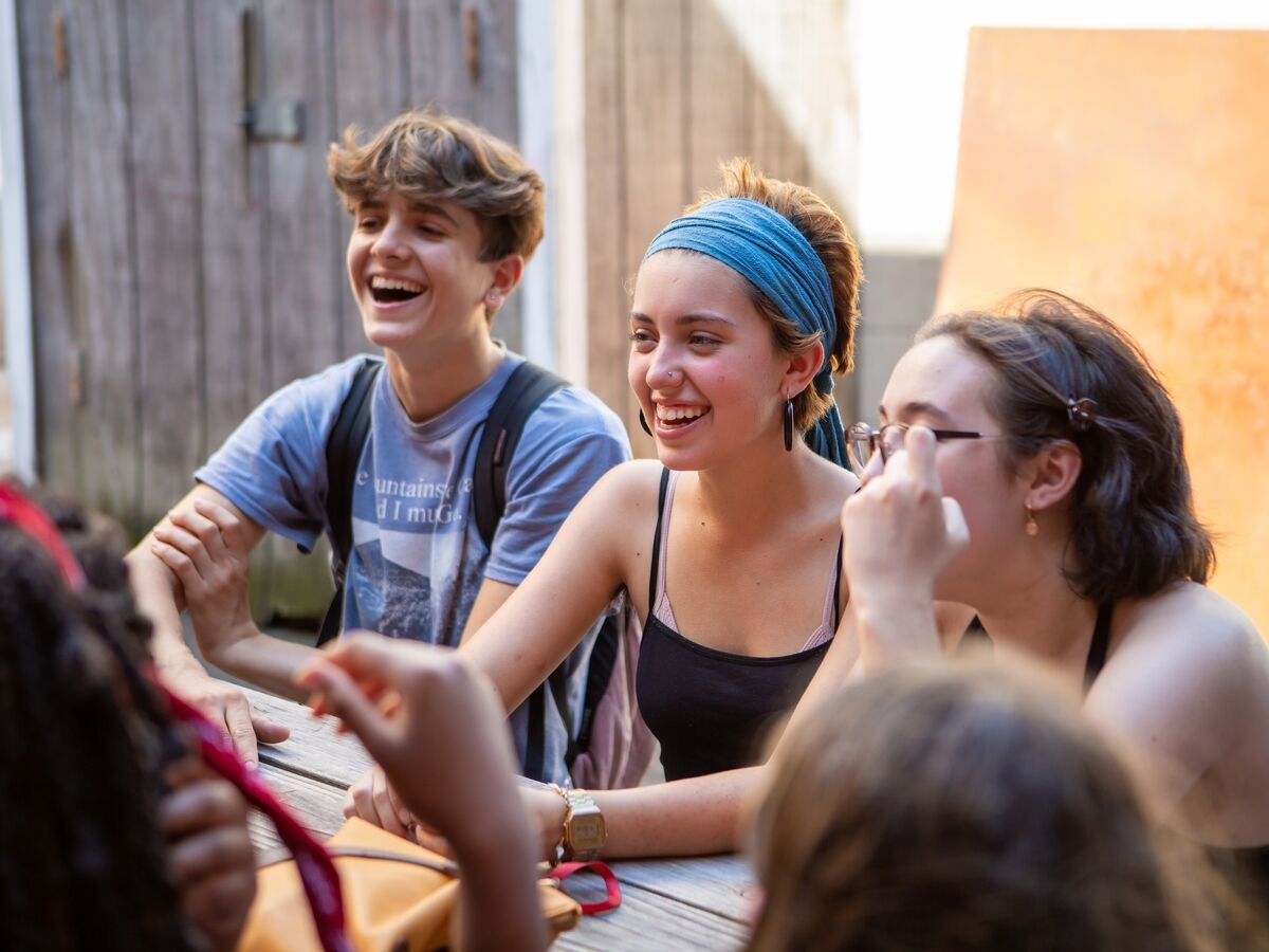 Students hang out outside around a table