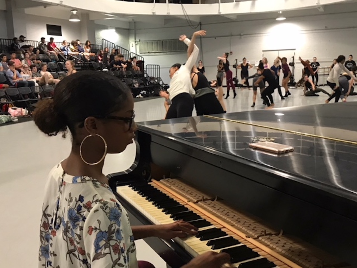 A pianist plays while dancers rehearse in the studio