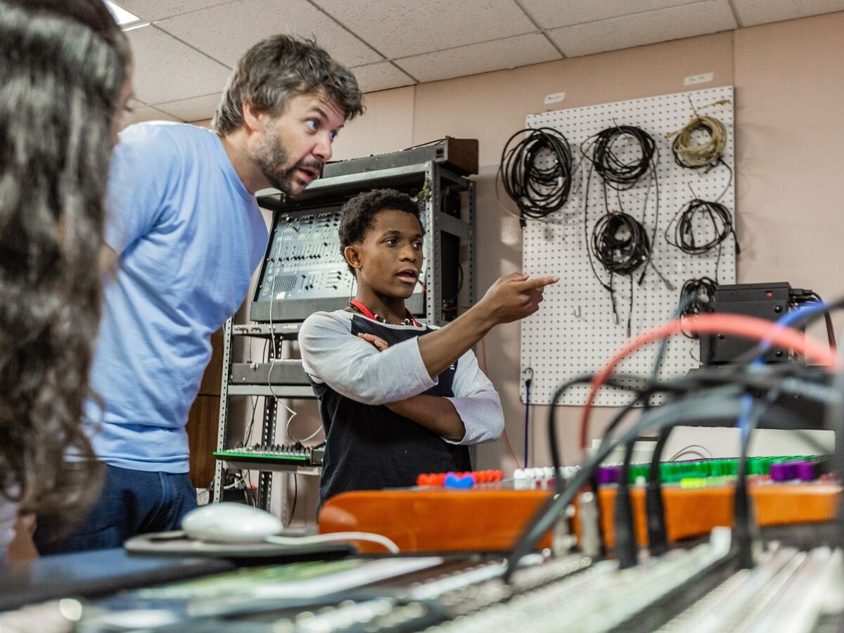 A teacher and student discuss audio production in the studio