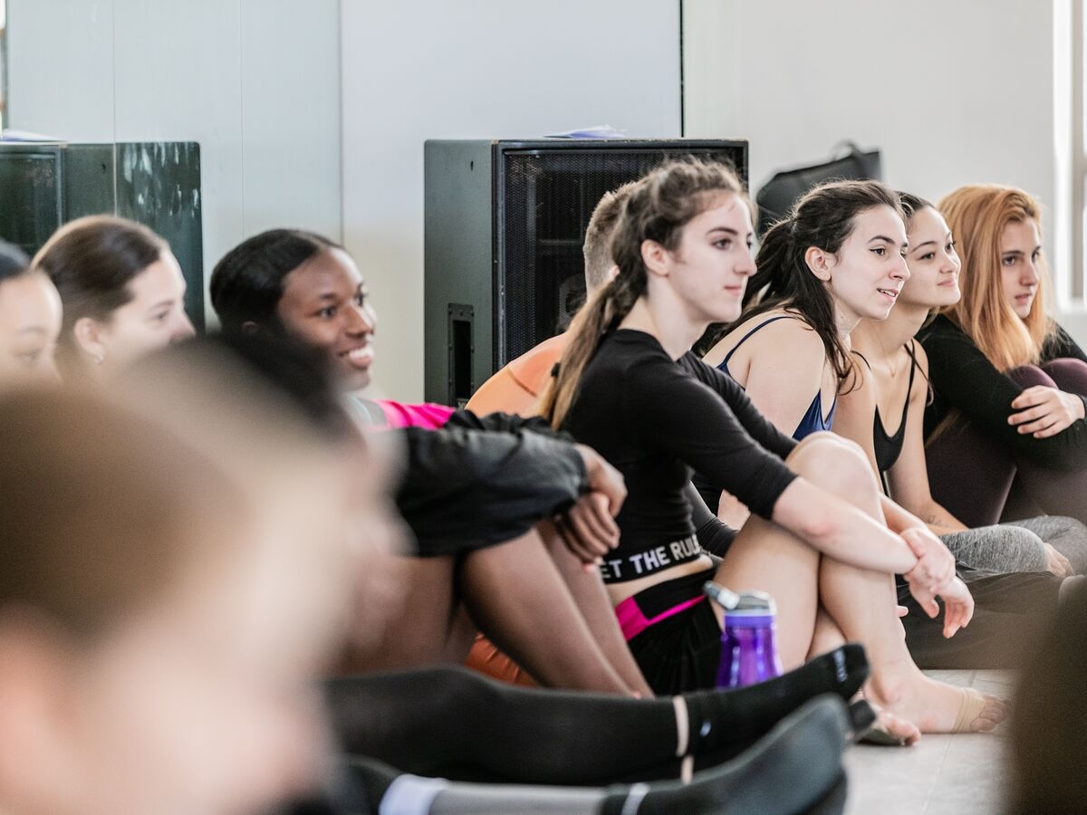 Dancers sit in the studio and have a discussion