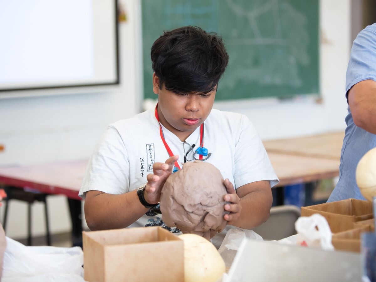 A Sculpture student shapes a head out of clay