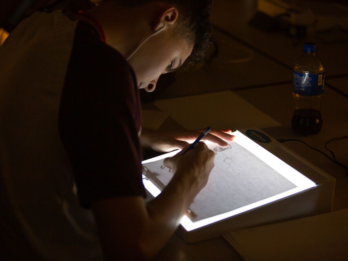 An Animation traces their work on a light box