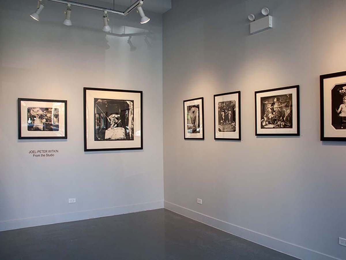 Installation view of Joel-peter Witkin: From The Studio at Catherine Edelman Gallery. Several photographs are pictured hanging on the white, gallery walls.