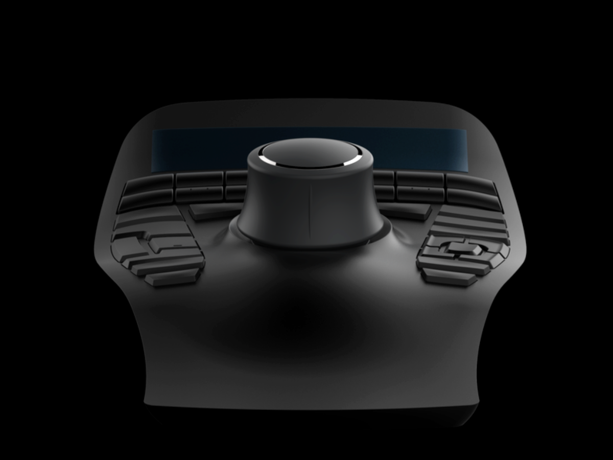 A rendering of a smooth, dark gray, plastic-looking object against a black background. The object has a cylindrical knob in the center and buttons surrounding it. 