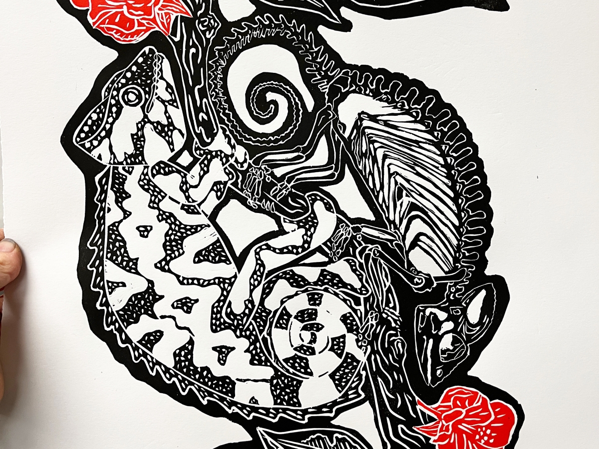 a linoprint of chameleons on a branch with flowers and leaves. one larger chameleon is rendered in dots and one is seen as if in xray, with bones visible. the flowers are red and the rest is black ink on white paper 