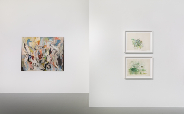 an installation shot of Larry Day's work in a gallery space. One painting featuring colorful all over abstracted forms hangs on the wall a wall to the left. Two smaller, landscape oriented framed works hang in a vertical row on a separate wall on the right side of the photo.
