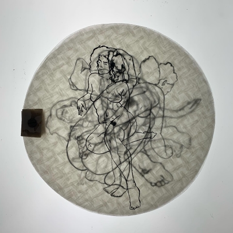 a papery disc with overlayed images of a nude body. the overlaid images fade into the background.