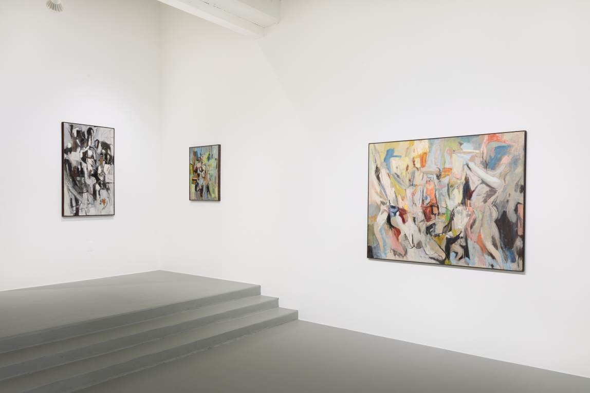 installation shot of work by Larry Day. Three abstract paintings of various sizes hang on white walls. A grey floor with three steps is also visible in the space.