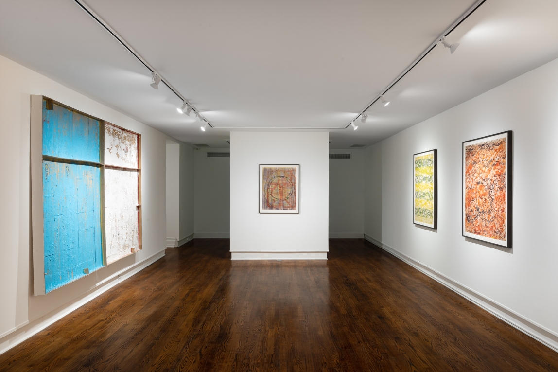 gallery view of large multicolored paintings hanging on the left, right and central walls.