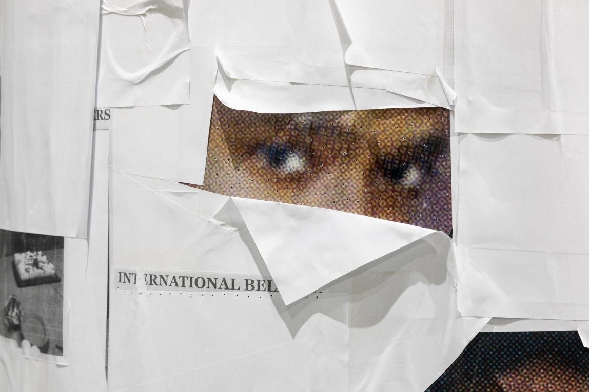 Close up image of column with a picture of someone's face covered in white printer paper, except for the eyes