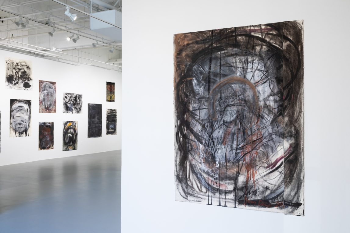 installation view of one drawing in foreground and series on another wall in background